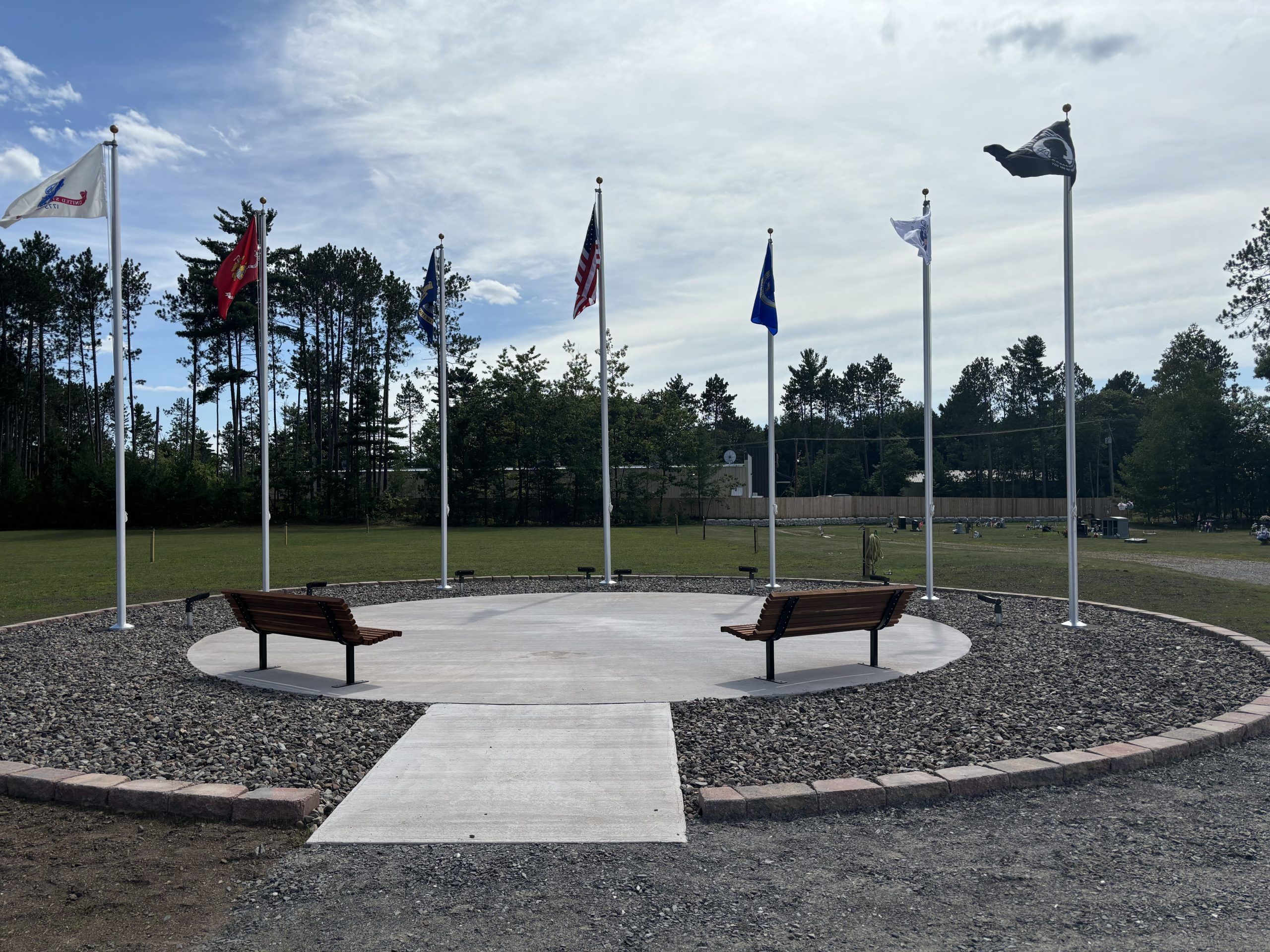 Veteran Memorial Park in Village of Baraga Cemetery with flags and two benches